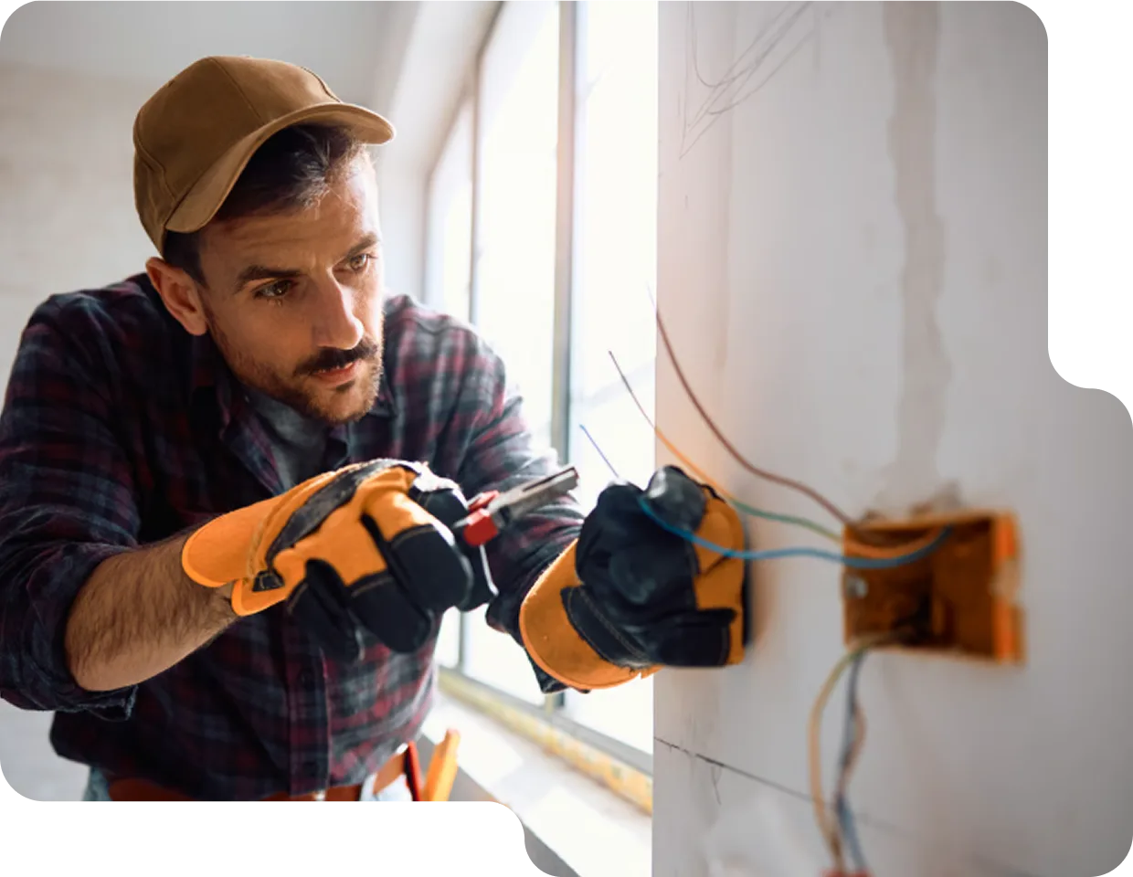 Electrician safely wiring a new electrical outlet into a residential wall