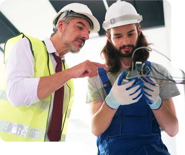 A happy homeowner consulting with a friendly LampPost electrician during a light fixture installation. A happy homeowner consulting with a friendly LampPost electrician during a light fixture installation.