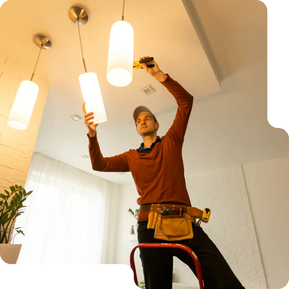 A happy homeowner consulting with a friendly LampPost electrician during a light fixture installation.